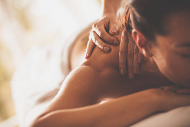 Close-up shot of a woman enjoying relaxing back and shoulder massage at spa.
