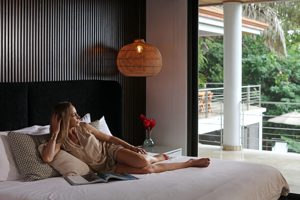 Woman laying on the bed while enjoying the view from her room in Casa Anjali