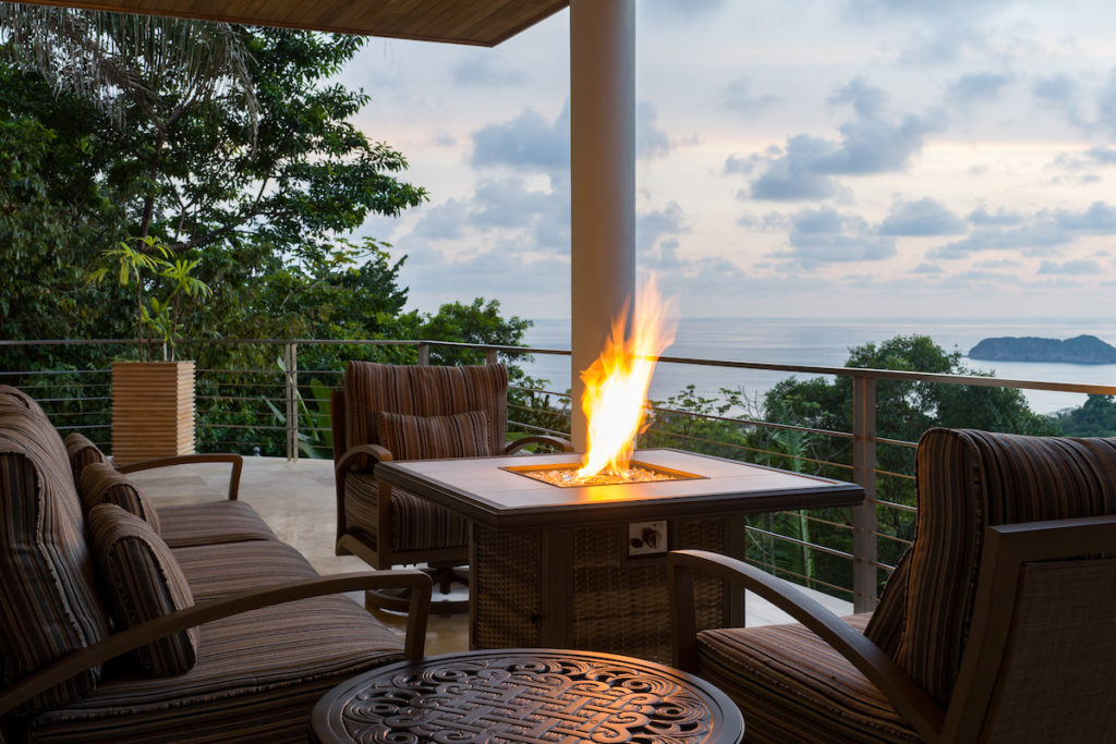 Fire pit table with couch and two sofas on the terrace at Casa Anjali