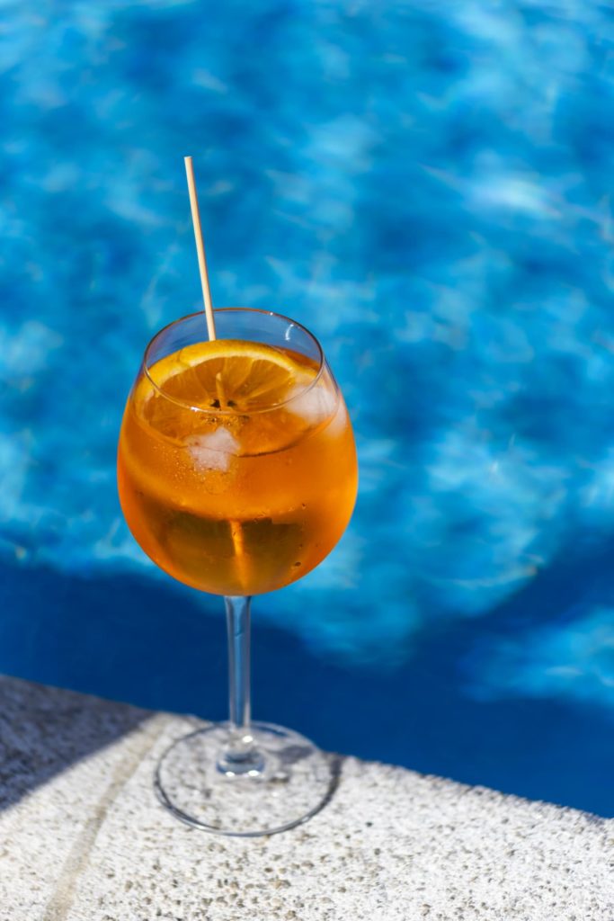 glass juice with orange slice isolated by poolside